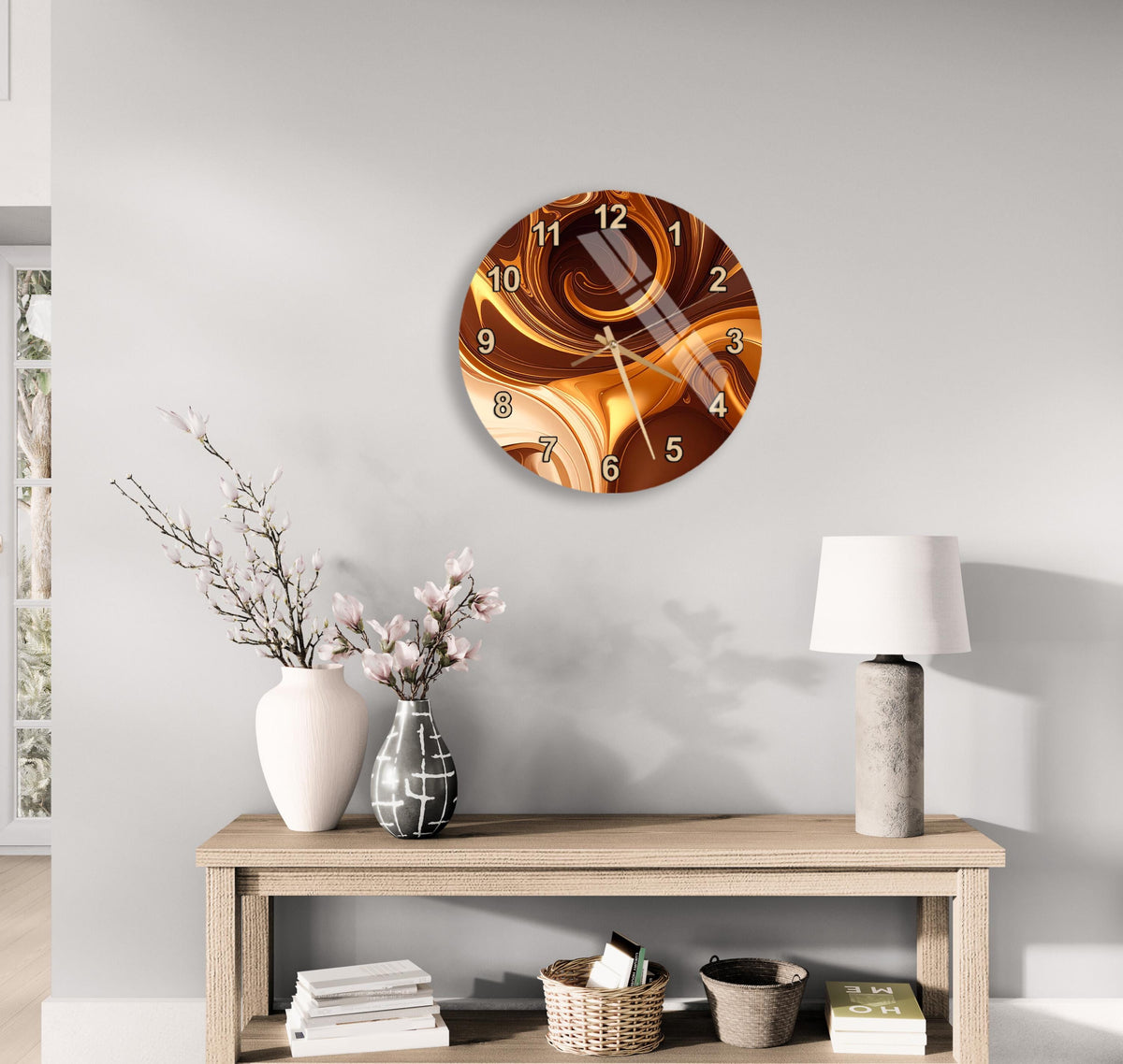 a modern living room with a wooden console table, a round wall clock with a swirling design, a white vase with pink flowers, and a white lamp on the table.
