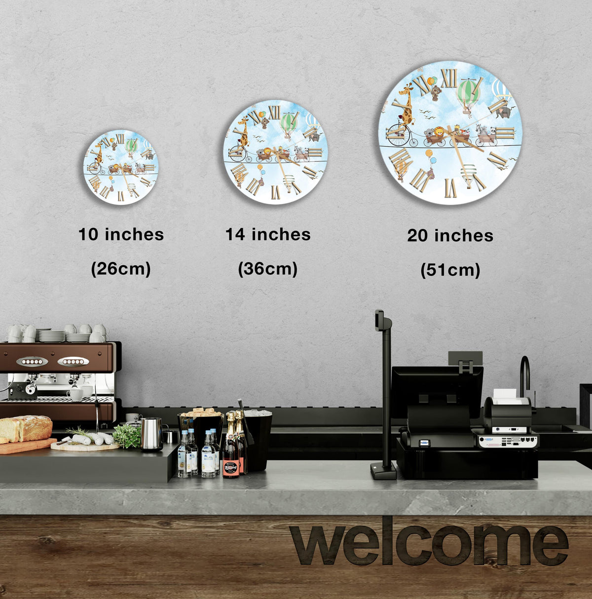 a wall with three different sizes of round wall clocks, each displaying a different scene. The wall clocks are arranged in a row, with the largest clock at the top, followed by the medium-sized clock, and the smallest clock at the bottom. The wall clocks are set against a gray background, and there is a counter with various items on it, such as bottles and a sandwich. The word "welcome" is also visible in the image.