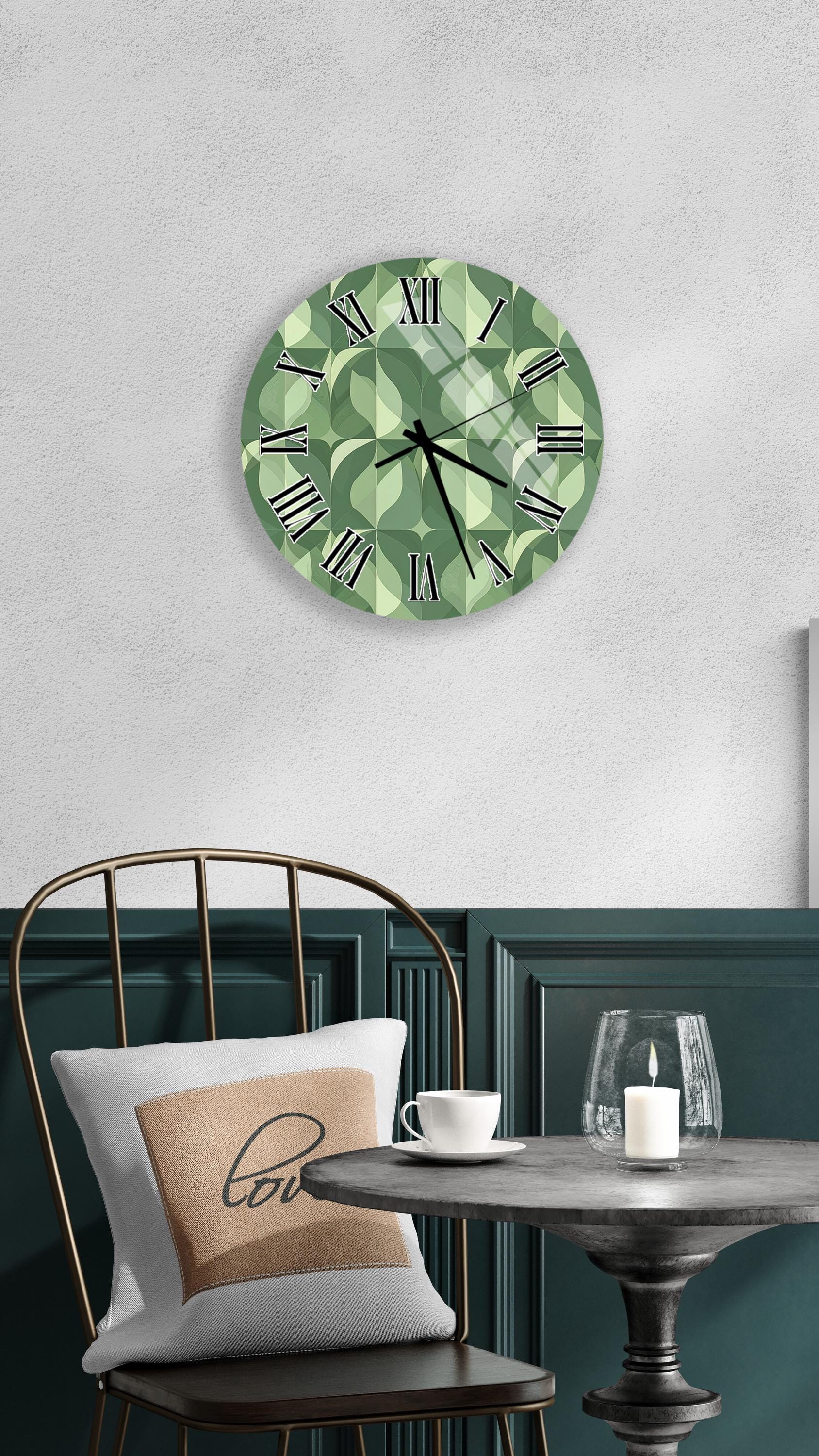 a modern and stylish interior design with a green and white geometric clock as the focal point. The clock is mounted on a white wall above a black chair with a white pillow. In front of the chair, there is a small table with a glass and a candle, creating a cozy and inviting atmosphere.