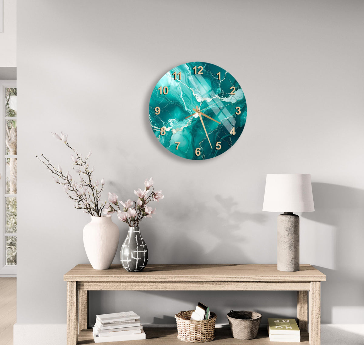 a modern living room with a large turquoise-colored wall clock hanging above a wooden console table. The table is adorned with a vase of flowers, a lamp, and a stack of books.