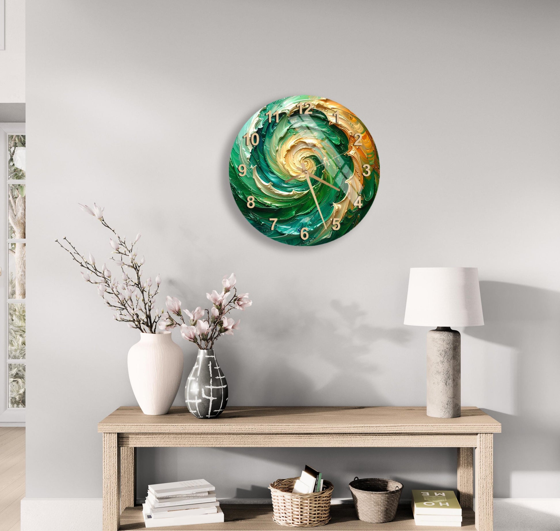 a modern living room with a wooden console table, a round wall clock with a swirling green and gold design, a white vase with pink flowers, a white lamp, and a stack of books.