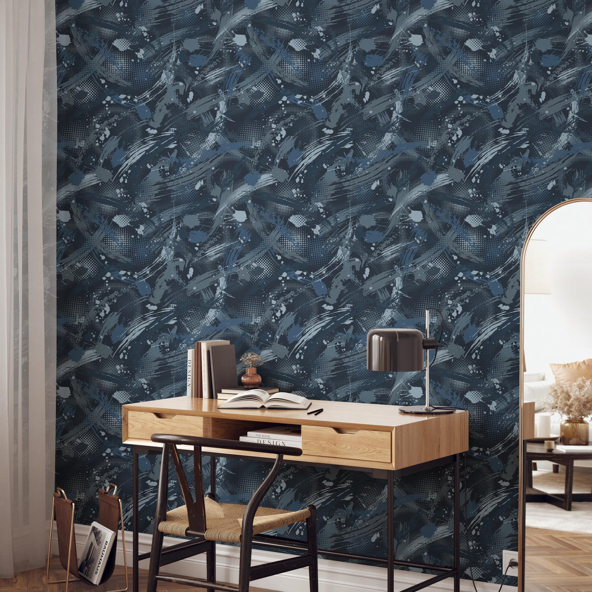 a modern workspace with a wooden desk, a black lamp, and a bookshelf. The wall behind the desk has a blue and white abstract pattern, creating a visually striking backdrop for the workspace.