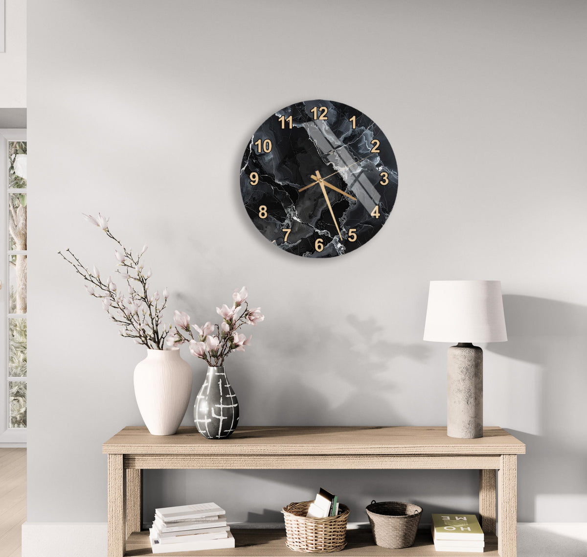 a modern living room with a wooden table, a white vase with pink flowers, a black and gold clock, and a lamp.