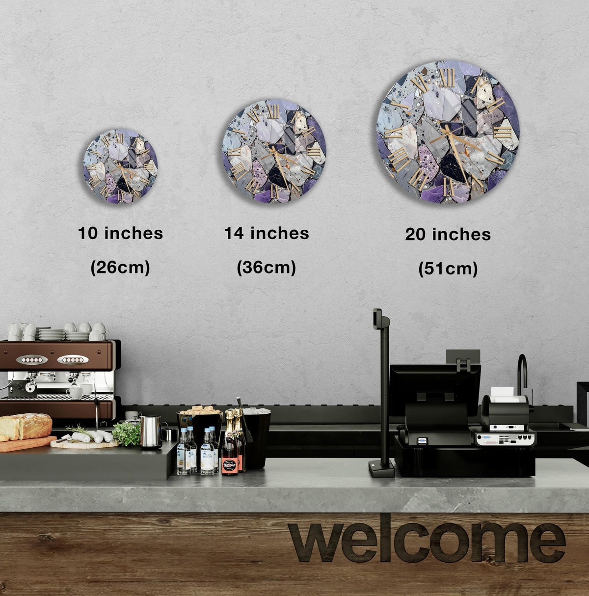 a counter with a cash register, a coffee machine, and various food items such as bottles and bread. Above the counter, there are three clock faces of different sizes, each displaying a different image. The largest clock is located above the counter, while the other two are positioned above the coffee machine. The image also includes text that provides the sizes of the clock faces in inches.