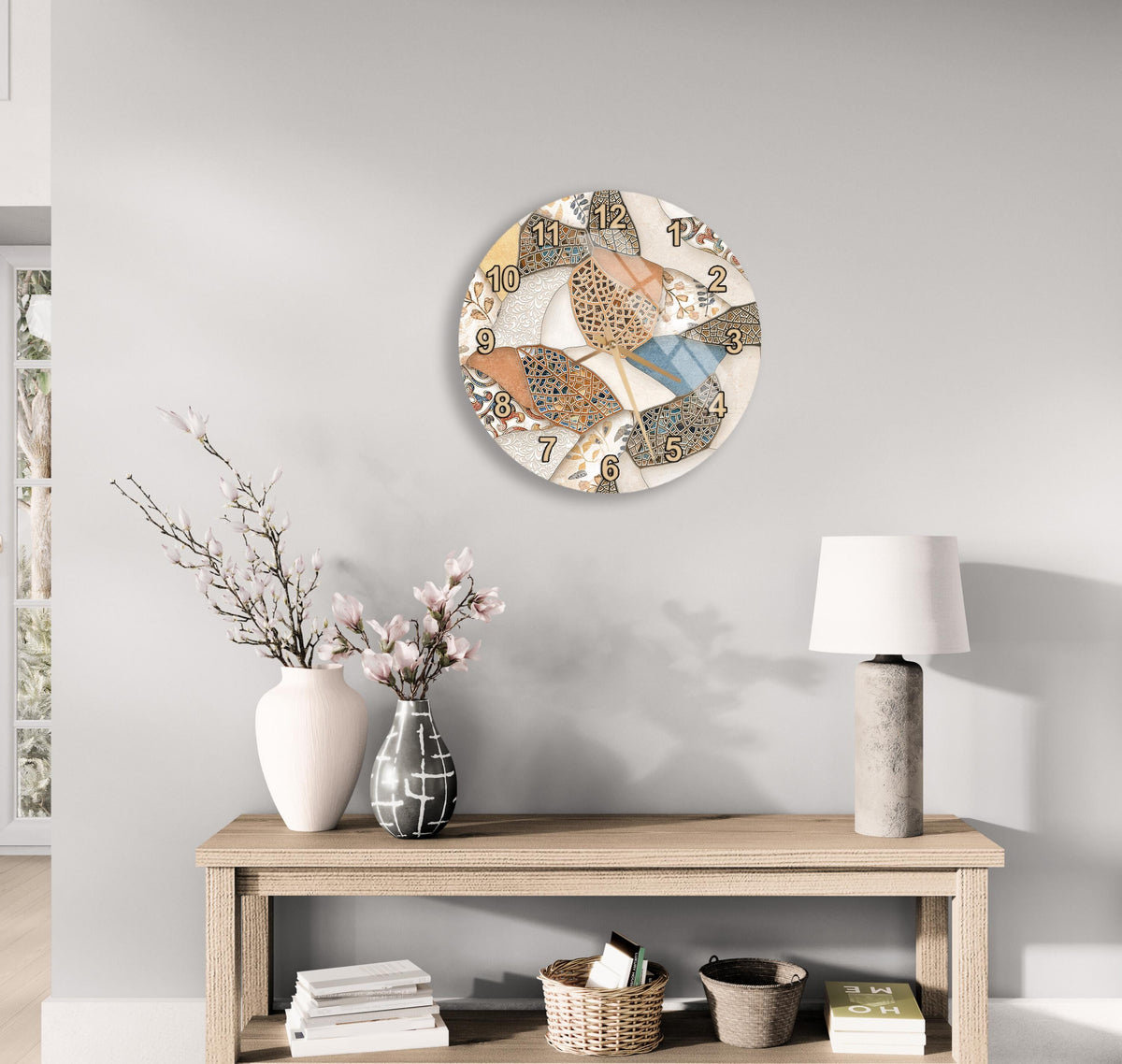 a wooden table with a white vase, a lamp, and a clock on the wall above it. The table also has a stack of books and a basket on it.