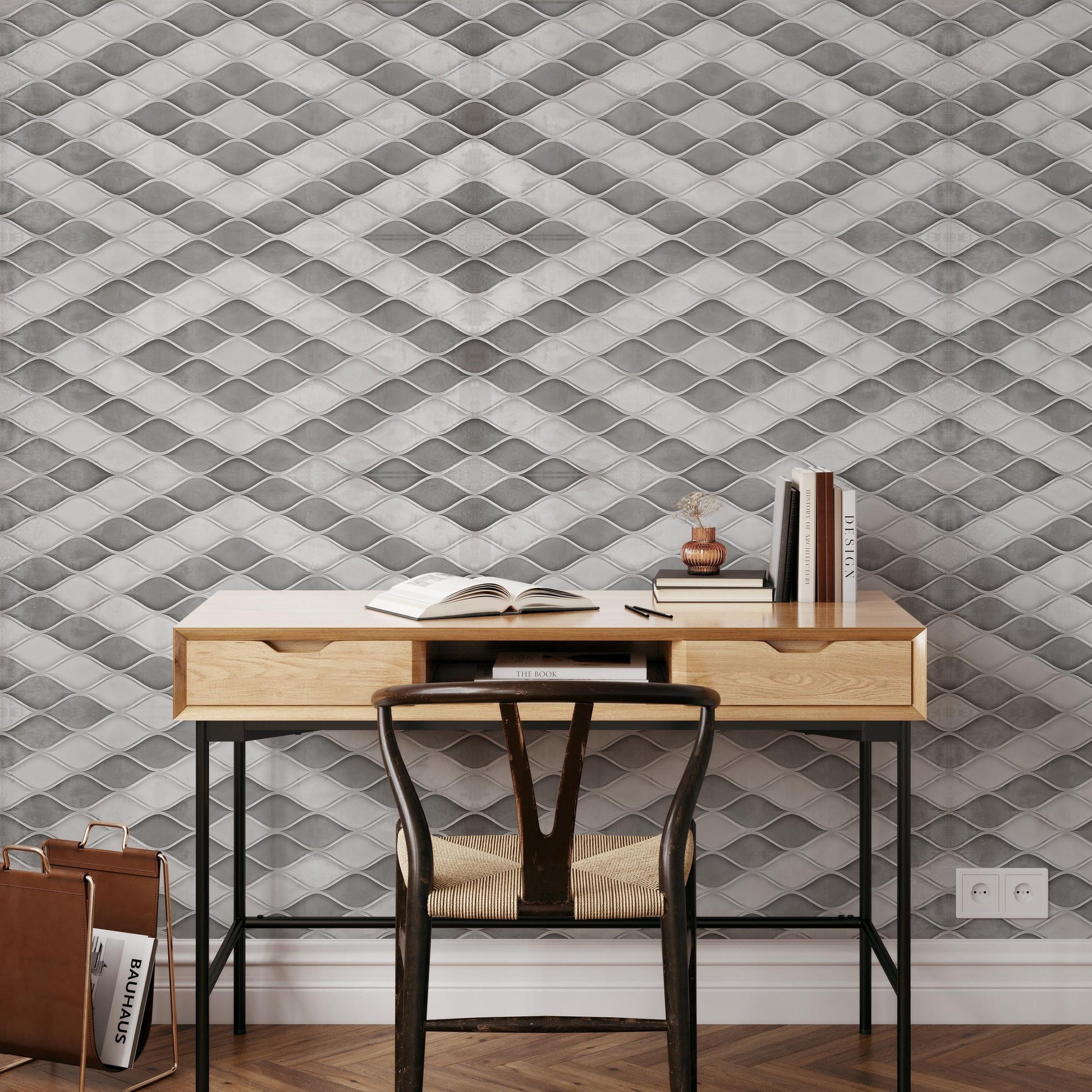 a modern workspace with a wooden desk, a black chair, and a bookshelf against a textured gray and white wall.