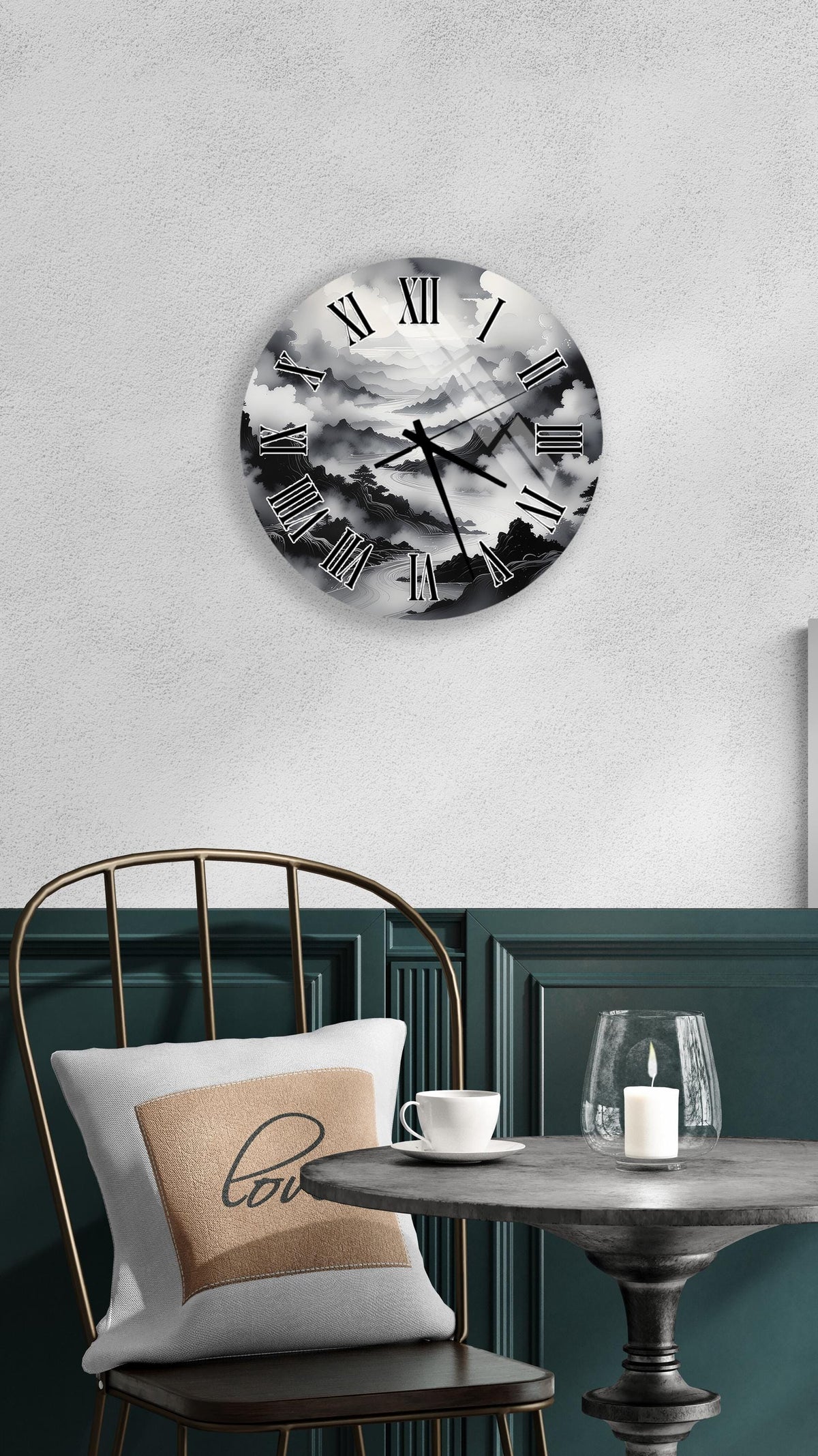 a wall clock with a black and white design, mounted on a wall above a table with a white tablecloth. The table has a candle and a cup on it, creating a cozy and inviting atmosphere.