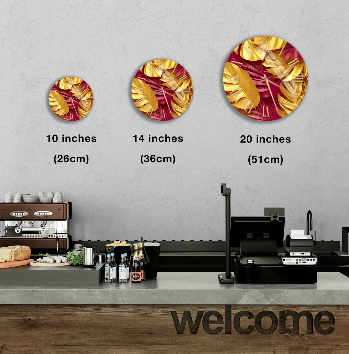 a counter in a restaurant with a welcome sign, and there are three different sizes of circular wall art depicting tropical leaves in gold and red colors.