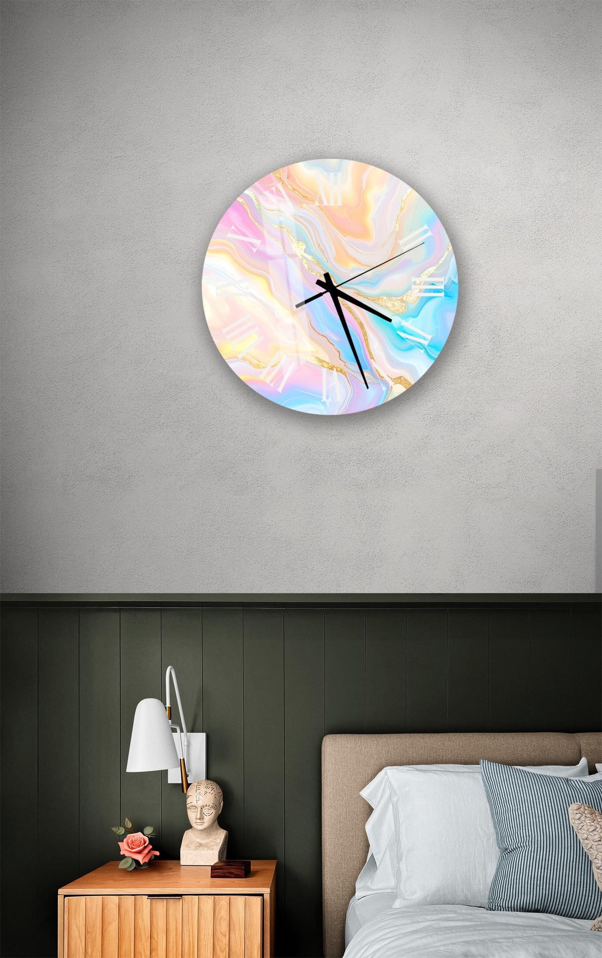 a bedroom setting with a round wall clock displaying a colorful abstract design, a wooden nightstand with a lamp, and a bed with white sheets and a blue and white striped pillow.