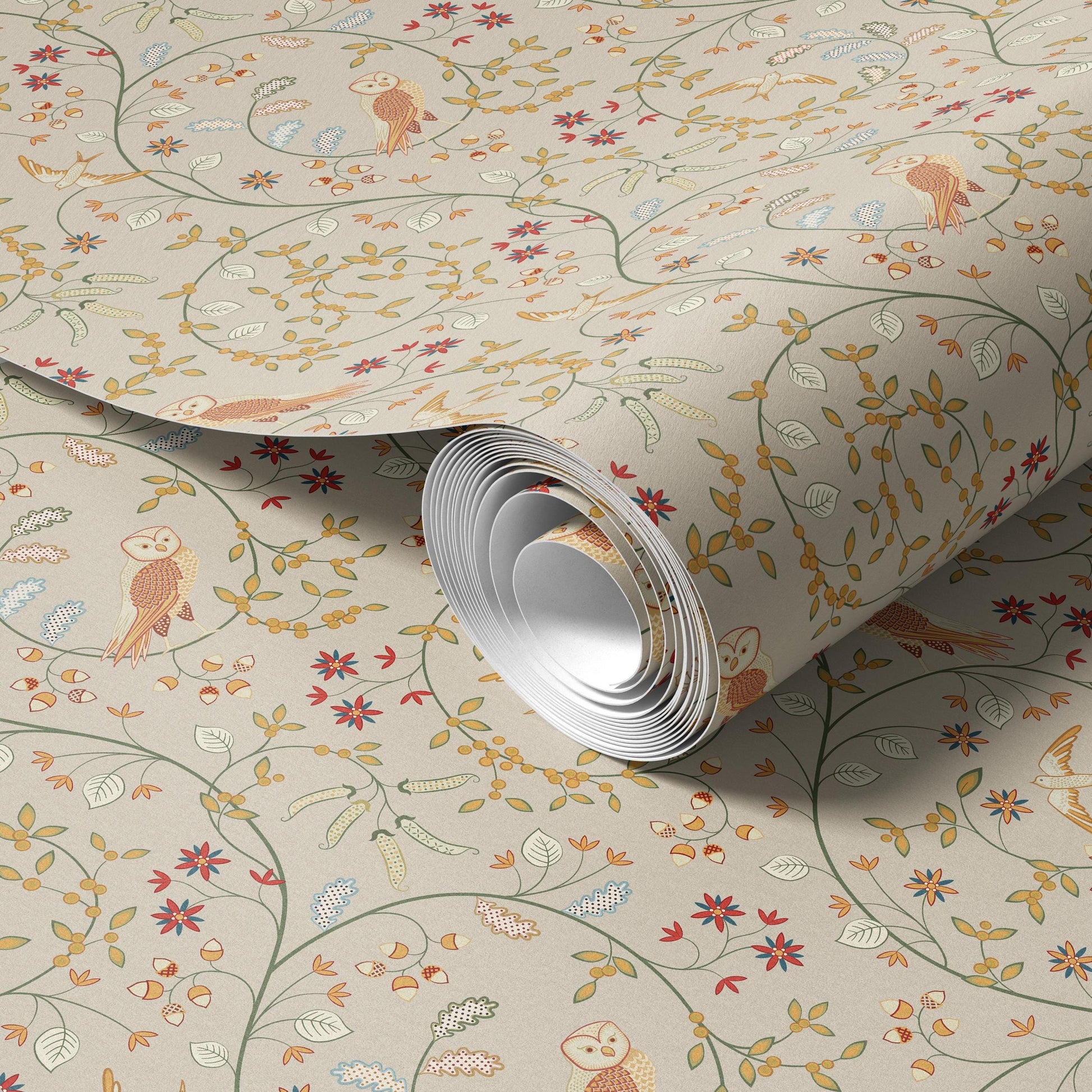 a roll of wallpaper with a floral pattern, including an owl design, and it is placed on a surface.
