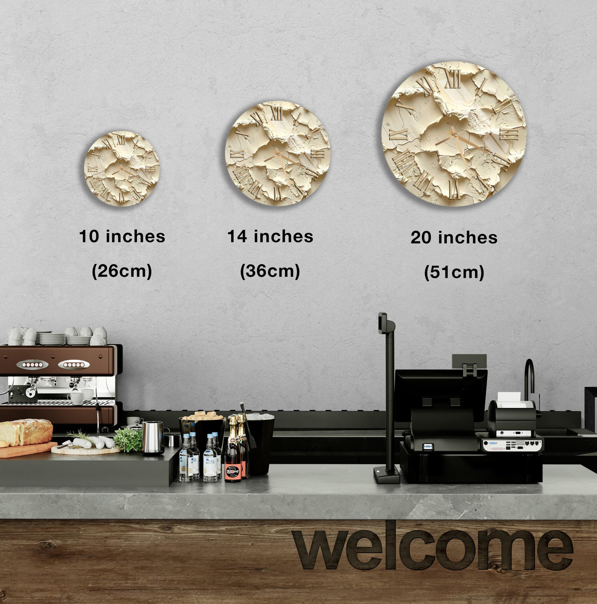 a counter in a restaurant with three different sizes of circular wall art displayed above it. The wall art is in the form of a circle with a textured surface. The counter has various items on it, including bottles and a cash register. The text "welcome" is visible on the counter.