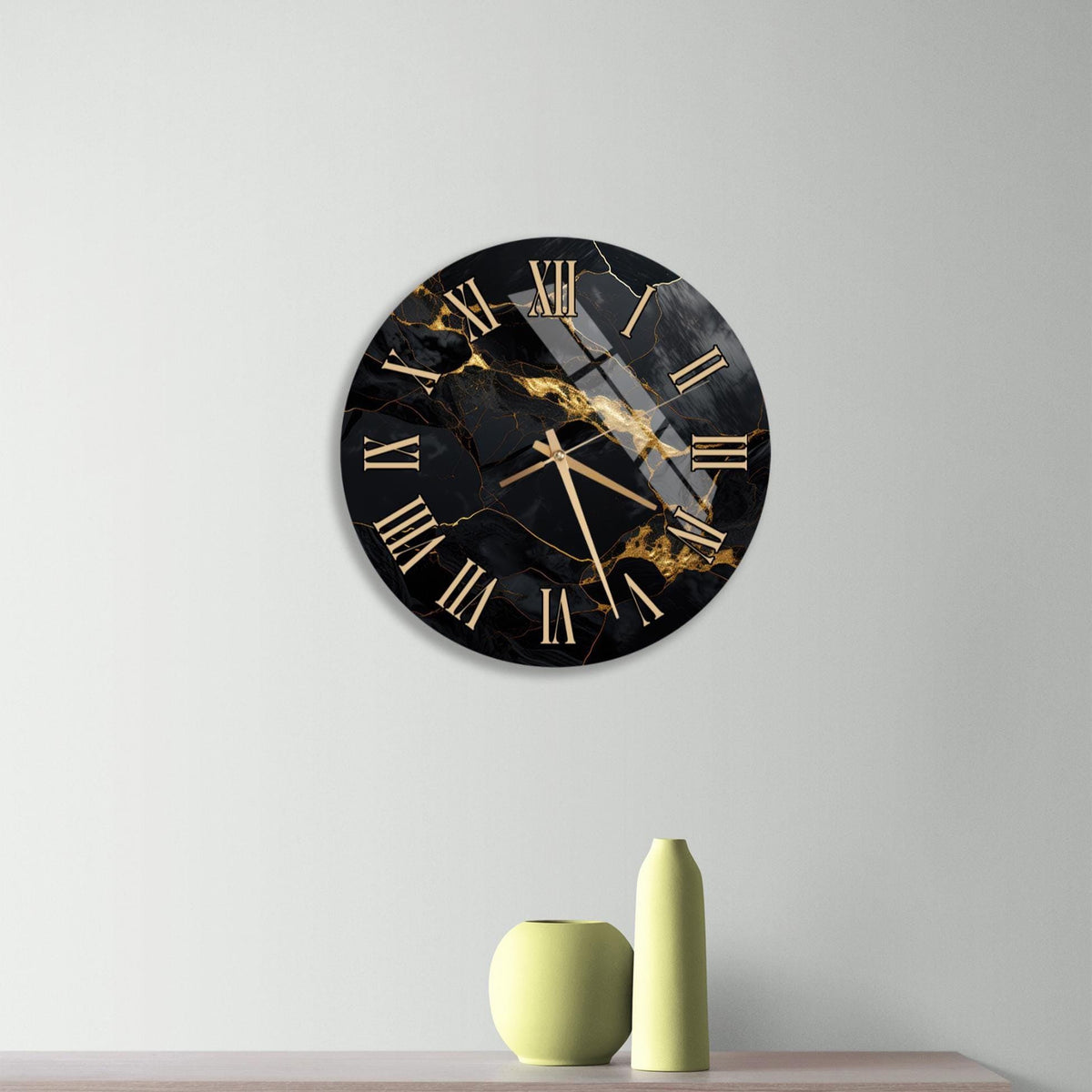 a modern black and gold clock with Roman numerals, mounted on a wall above a wooden dresser with three drawers.