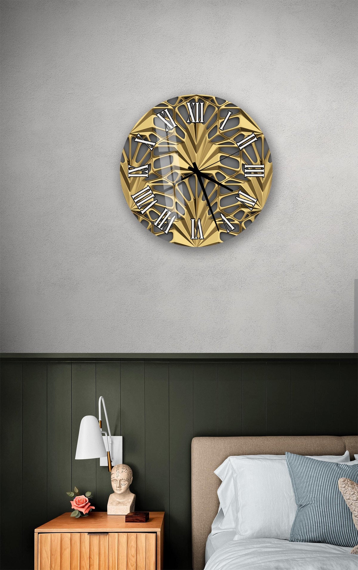 a bedroom setting with a large, ornate gold clock hanging on the wall above a bed. The clock has a unique, intricate design with Roman numerals. The room has a dark green wall, a wooden nightstand with a lamp, and a white headboard.