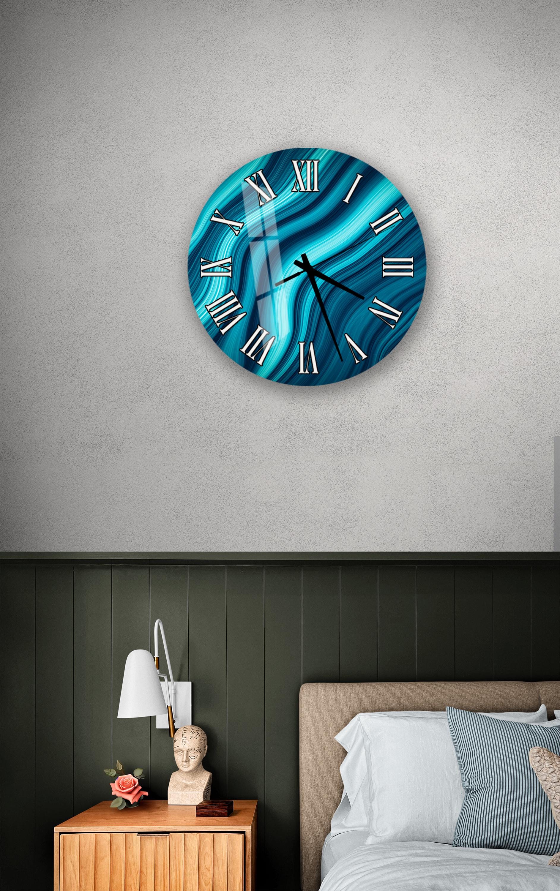 a bedroom setting with a large, round clock with a blue and white swirl design on the wall above a bed with white pillows and a gray headboard.