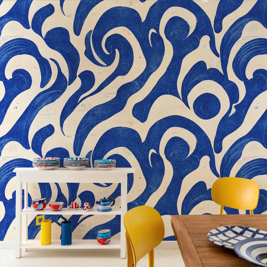 a dining area with a white table and yellow chairs, set against a wall with a blue and white abstract pattern. The table has several plates and bowls on it, and there are also some colorful vases and cups displayed on the table.
