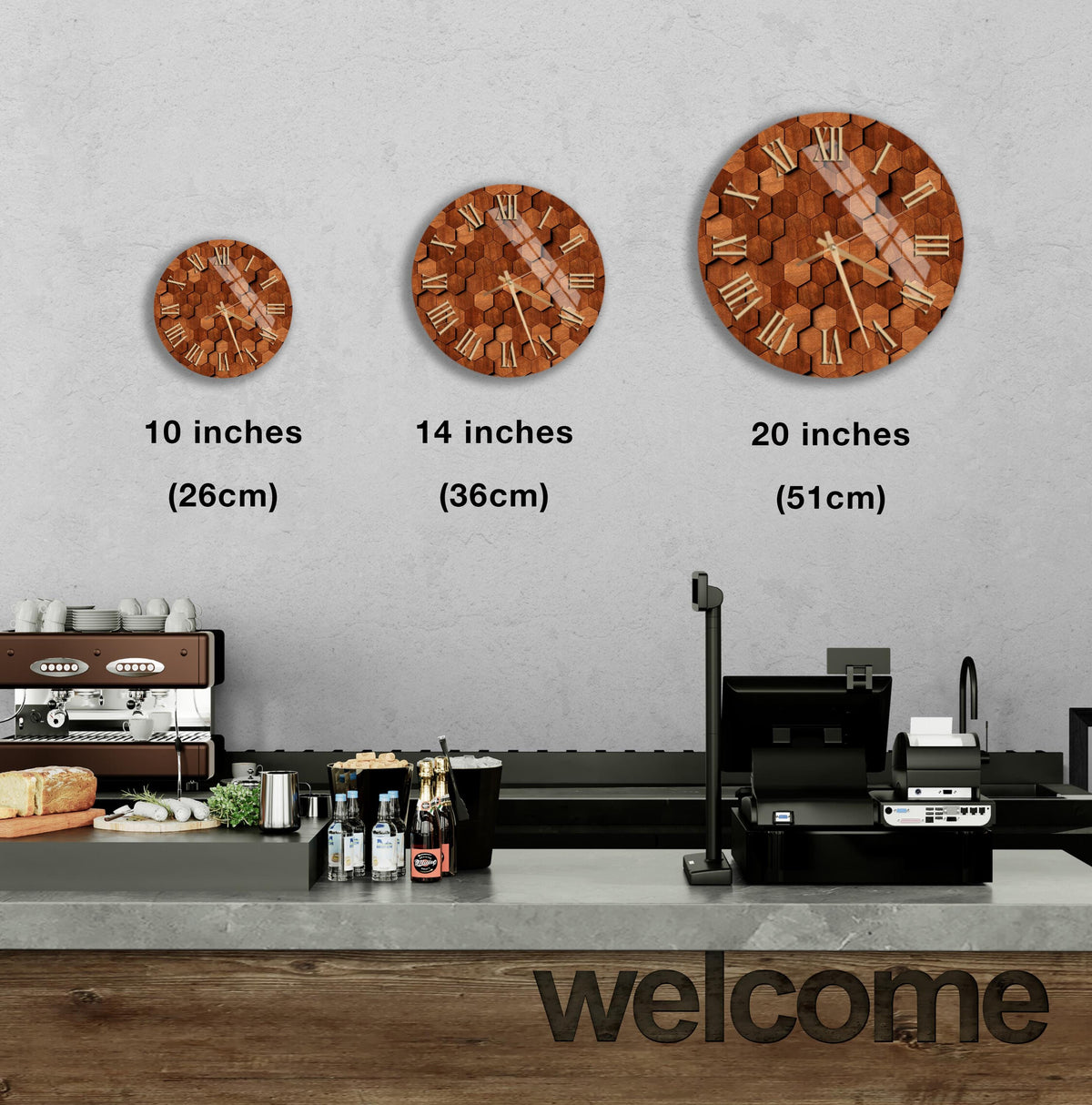a wall with three different clock designs, each representing a different size: 10 inches, 14 inches, and 20 inches. Below the clocks, there is a counter with various items such as bottles and a sandwich. The word "welcome" is also visible in the image.