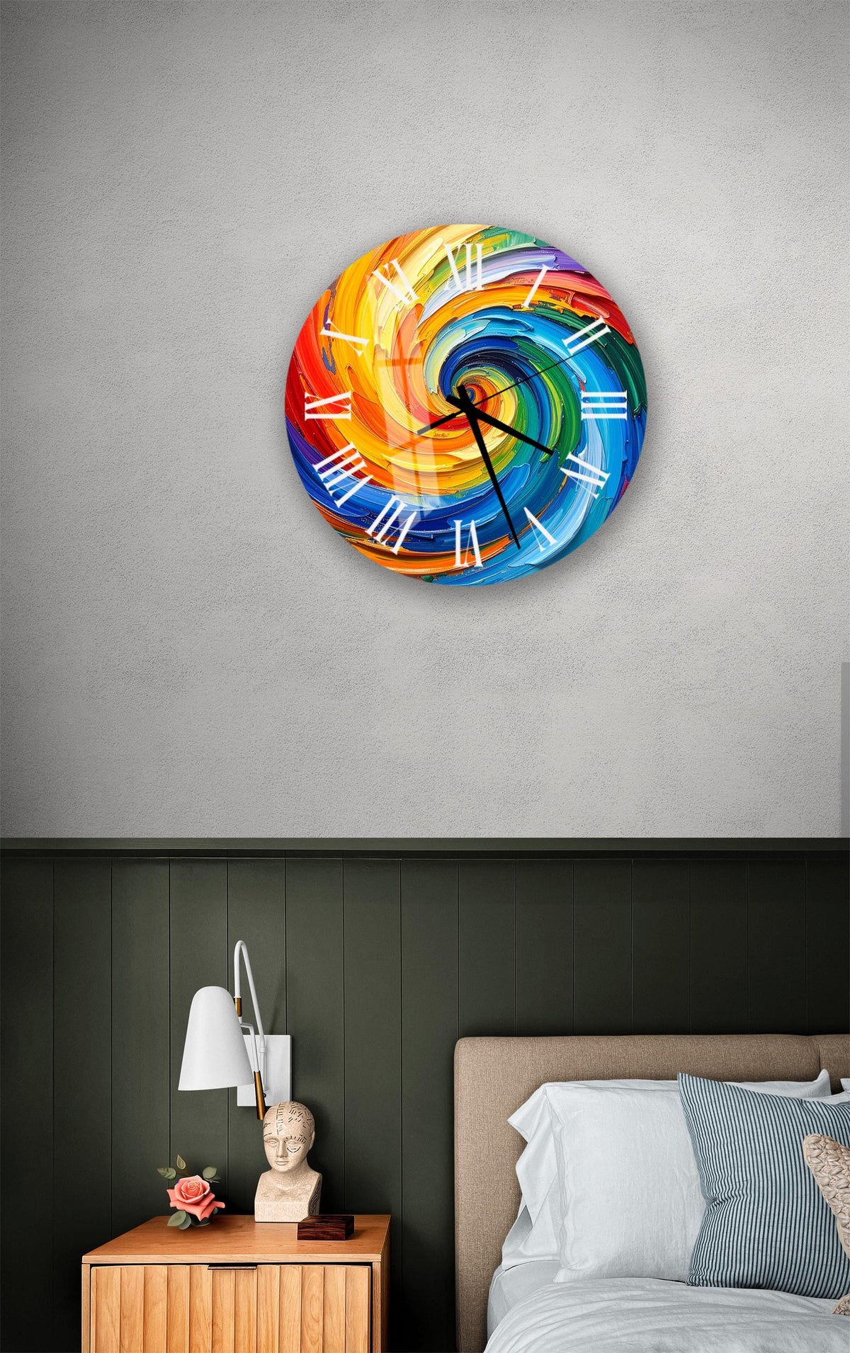 a colorful, abstract clock with swirling patterns on its face, mounted on a wall above a bedside table with a lamp and a small statue.