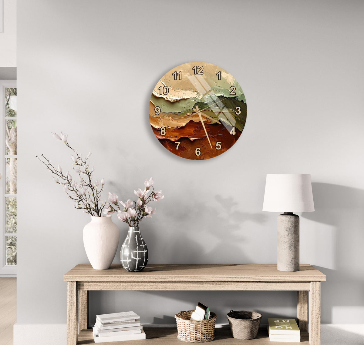 a wall clock with a colorful design, a wooden table with a lamp, a vase with flowers, and some books on a shelf.