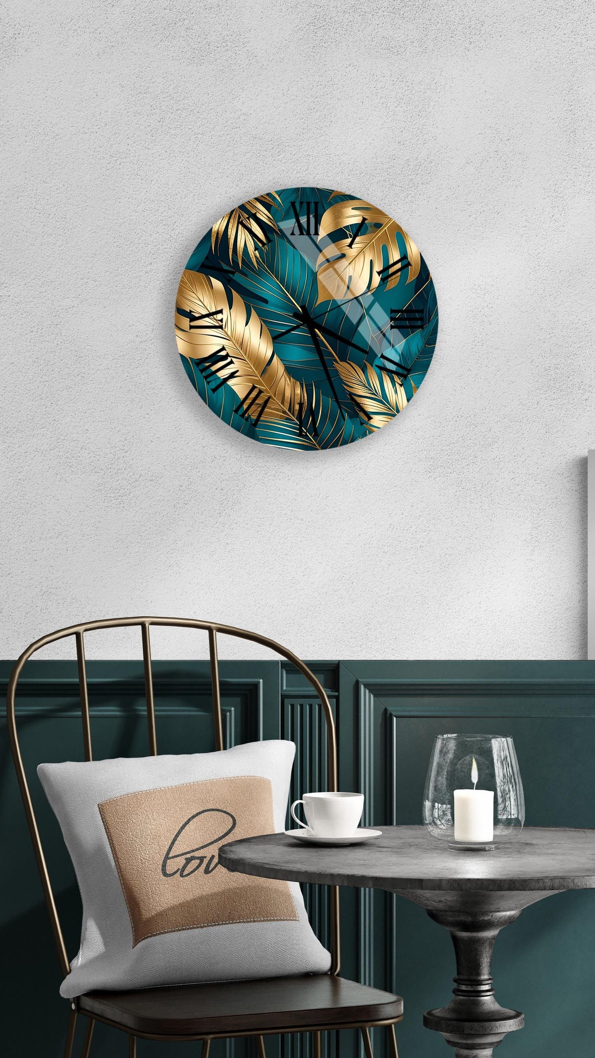 a modern and stylish interior design with a round wall clock featuring a tropical leaf pattern in shades of blue and gold, a white pillow with a black "love" message, a black metal chair, and a small table with a candle and a glass.