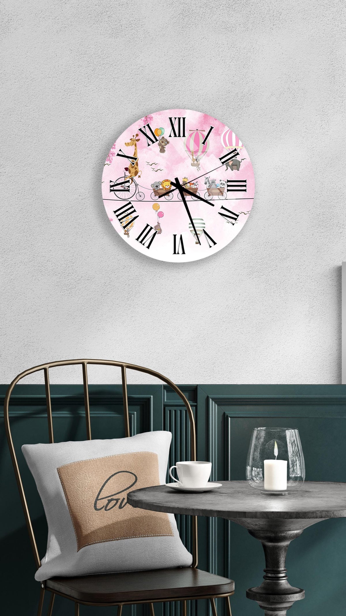 a wall clock with a pink and white design, a white table with a candle and a cup, and a green chair with a pillow.