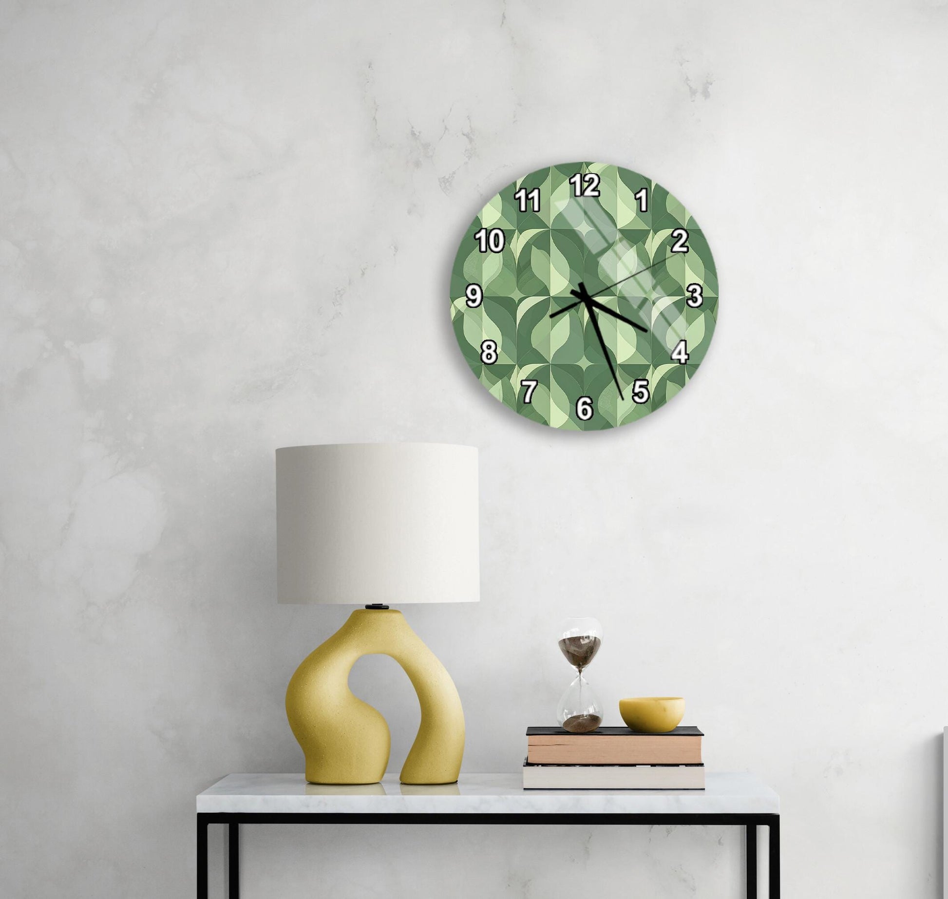 a modern living room with a white marble wall, a round clock with a green geometric pattern, a yellow lamp with a unique curved base, and a small table with a book and a glass of wine.