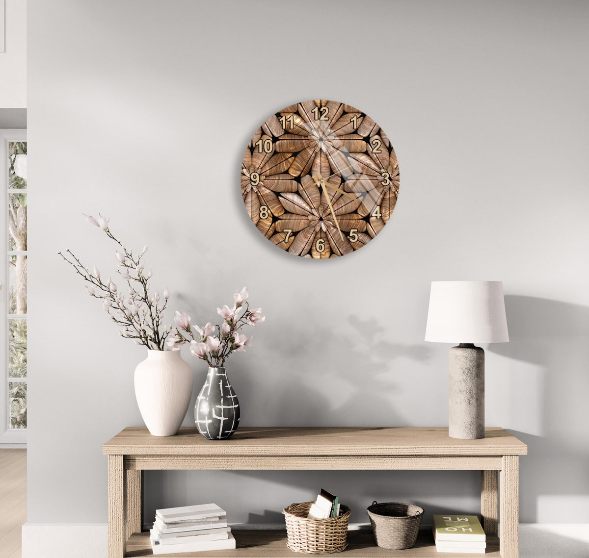 a wooden table with a lamp, a vase with flowers, and a clock on the wall above it.