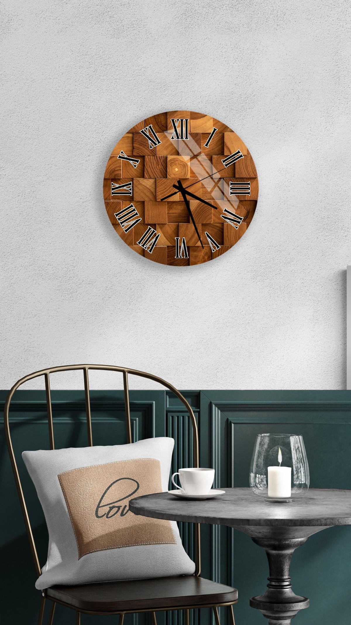 a wooden clock with Roman numerals mounted on a wall above a table with a white tablecloth and a candle.