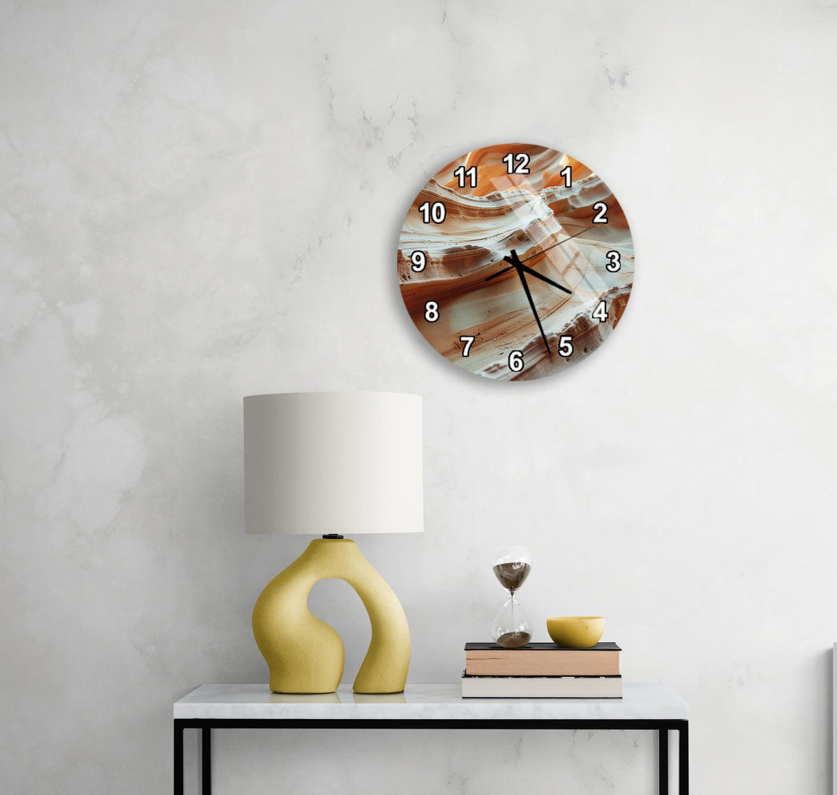 a modern wall clock with a unique design, a yellow lamp on a white table, and a stack of books and a glass of wine on the table.