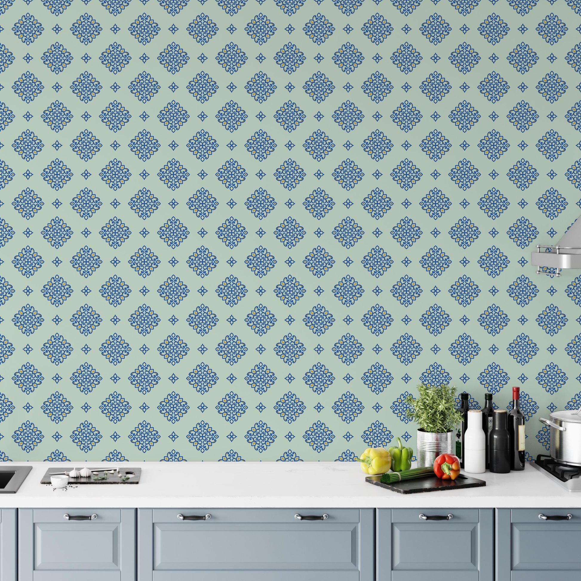 a kitchen counter with various kitchen items, including a potted plant, a cutting board, and several bottles and a cup. The counter is set against a wall with a repeating pattern of blue and green floral designs.