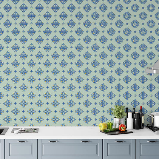 a kitchen counter with various kitchen items, including a potted plant, a cutting board, and several bottles and a cup. The counter is set against a wall with a repeating pattern of blue and green floral designs.