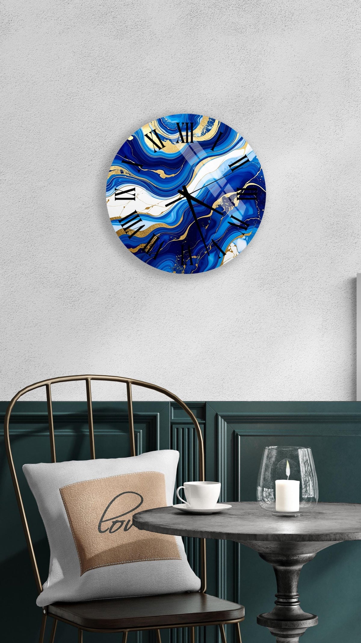 a modern and stylish interior design with a round wall clock featuring a blue and gold marble pattern, a white table with a candle and a cup, and a black metal chair with a white pillow.