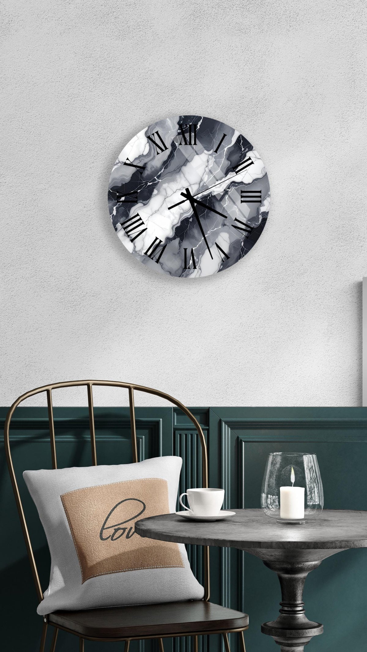 a modern black and white clock with a marble-like design, mounted on a wall above a table with a white tablecloth. The table has a candle and a cup on it, creating a cozy and inviting atmosphere.