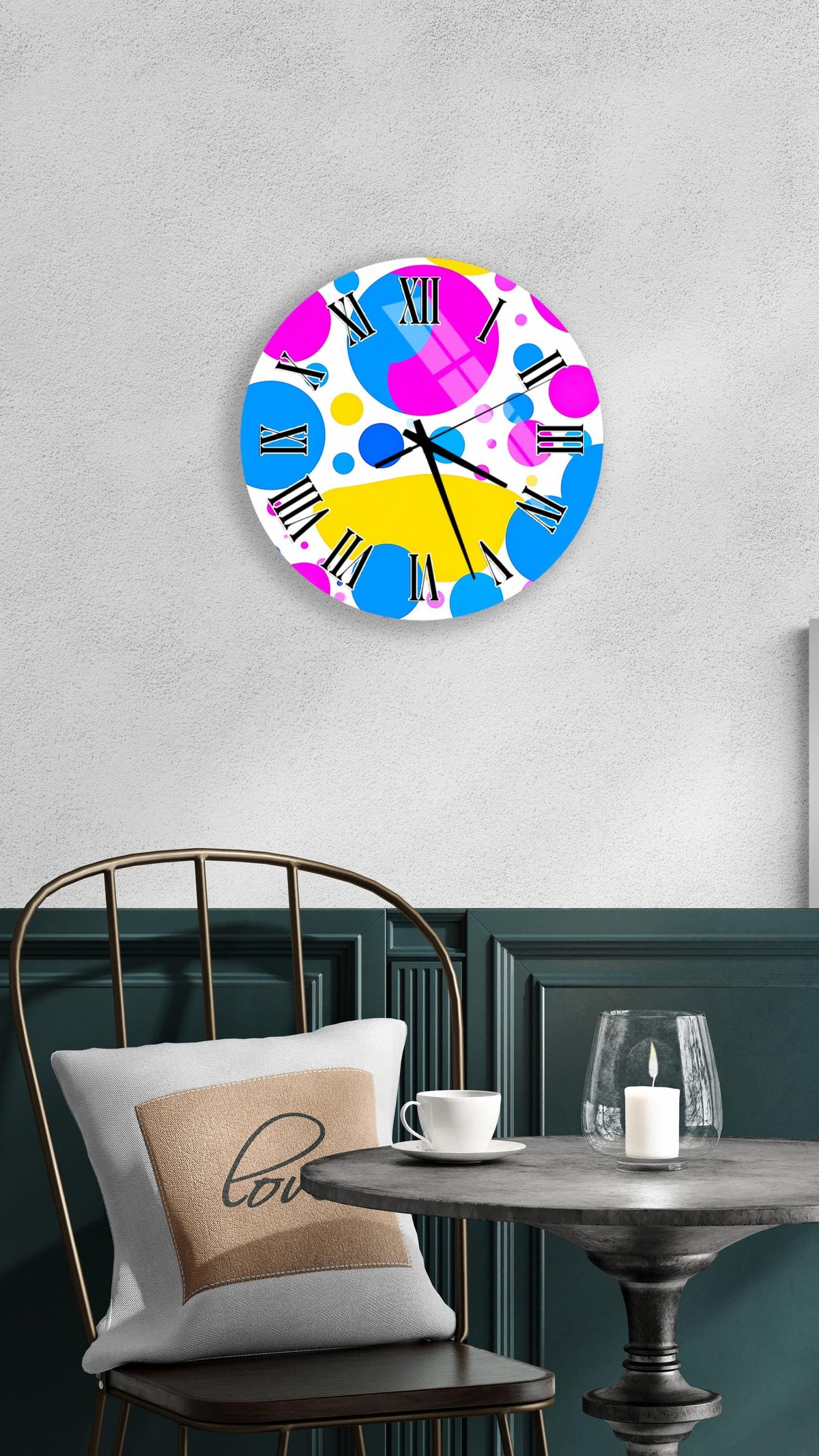 a colorful wall clock with a unique design, hanging on a wall above a table with a white tablecloth.