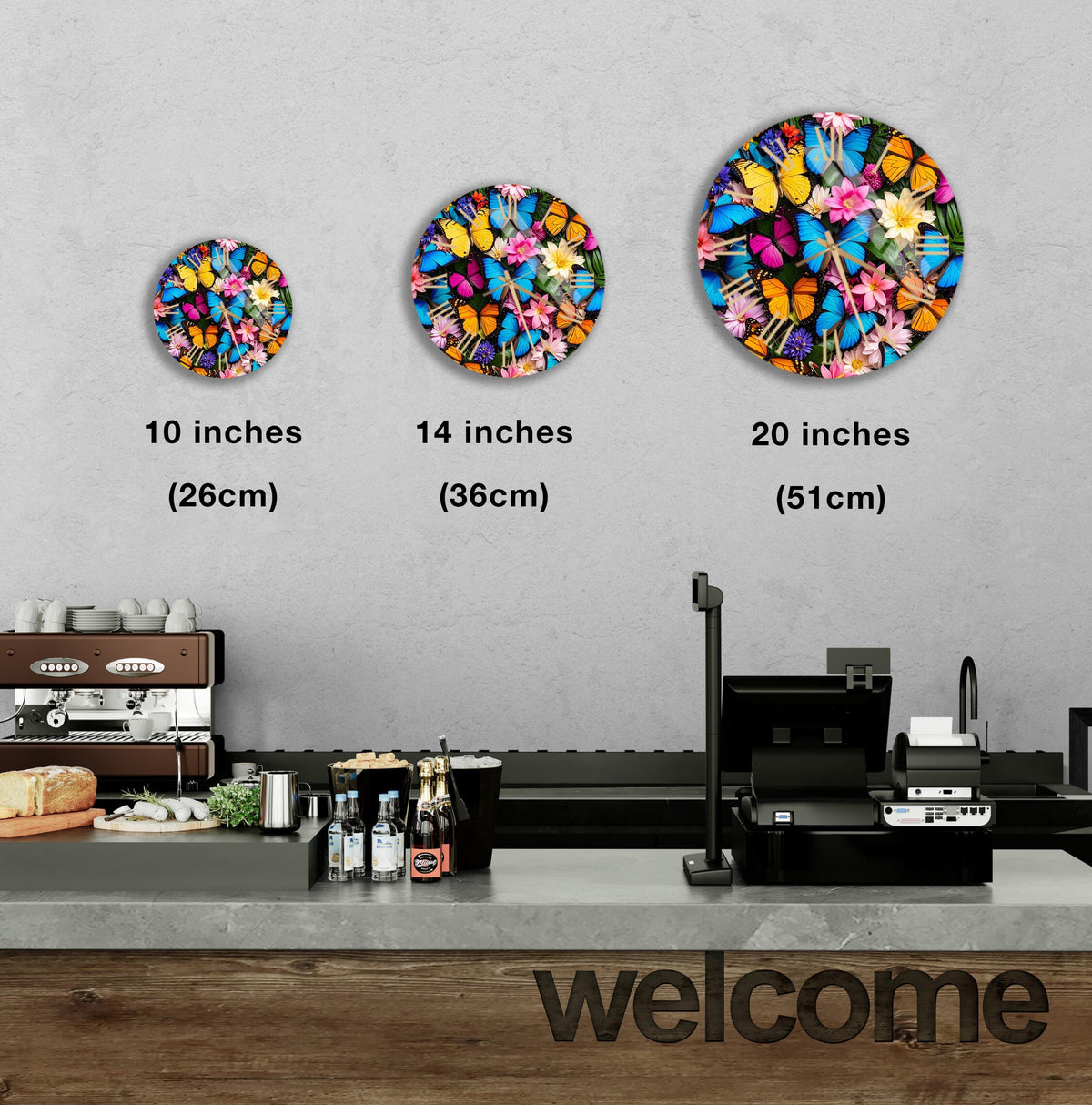 three circular wall art pieces with different butterfly designs, each representing a different size: 10 inches, 14 inches, and 20 inches. The artworks are displayed above a counter in a cafe setting.