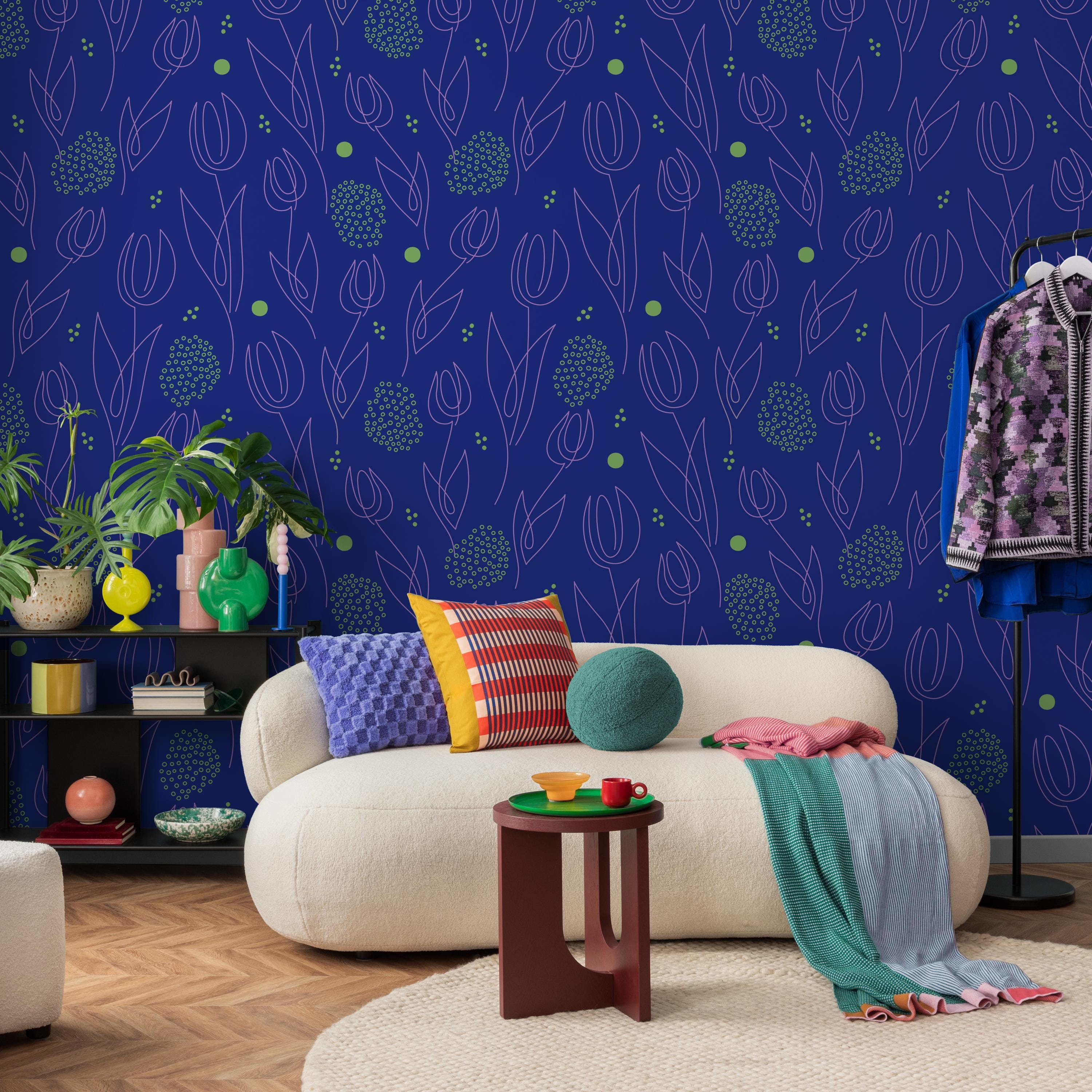 a vibrant and eclectic living room with a white sofa adorned with colorful throw pillows, a wooden coffee table, and a patterned rug. The room is decorated with various plants, vases, and other accessories, creating a lively and visually engaging space.