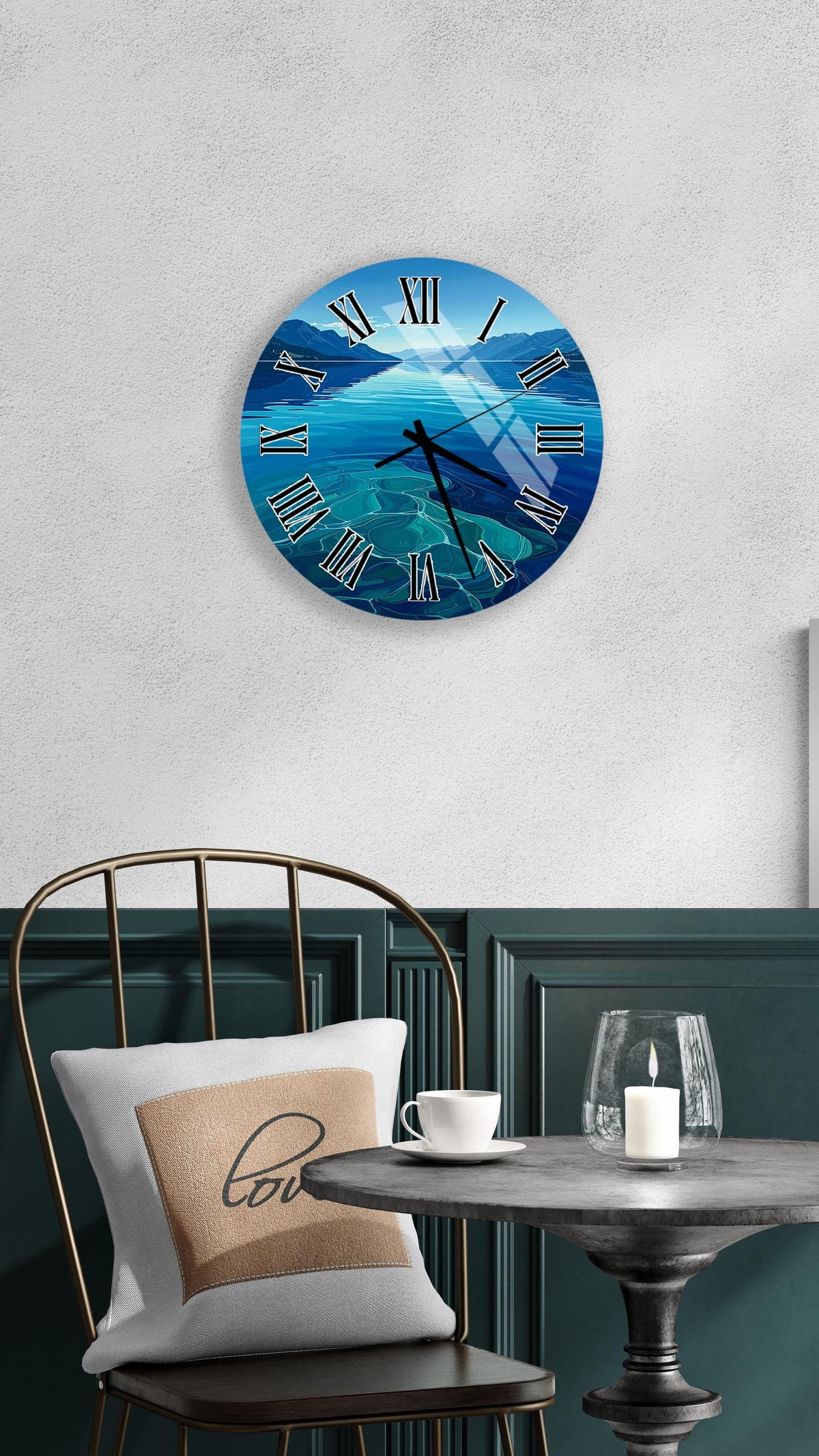 a wall clock with a blue ocean scene, a white table with a candle and a cup, and a black chair with a pillow.